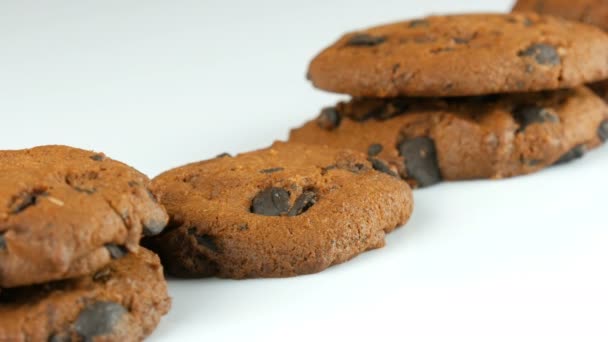 Galletas de chocolate sobre fondo blanco elegante ack y una superficie de espejo — Vídeos de Stock