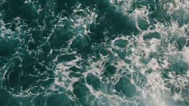 Beautiful turquoise sea water with waves and white foam close up top view. The ship floats on sea and cuts the waves — Stock Video