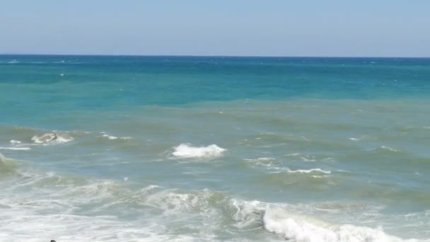 Hermoso mar tricolor con diferentes tonos de azul turquesa y verde oscuro con olas y espuma blanca en él — Vídeo de stock