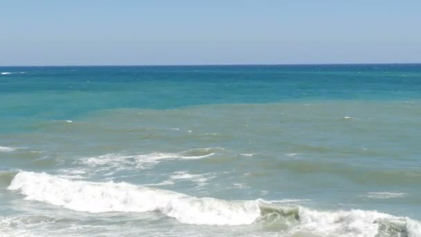 Beautiful tricolor sea with different shades of turquoise blue and dark green with waves and white foam on it — Stock Video