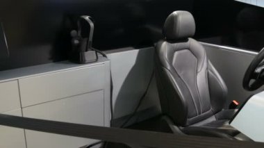 Araba simülatörü. Deri koltuk ve direksiyon. BMW kompleksi. Sergide yeni gelişmiş arabalar duruyor. Bmw Welt şirketinden yeni modern arabalar..