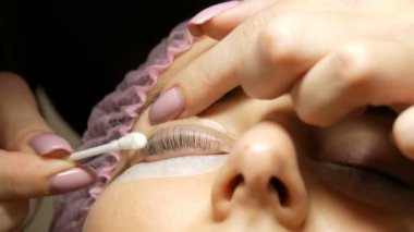 Kirpikleri kıvırmak için silikon bigudiler ya da bigudiler. Kaplama ve botoks için profesyonel prosedür modern şifa kirpiklerini kirletir. Pamuklu çubukla kozmetik uzmanı kirpikleri düzgünce temizliyor