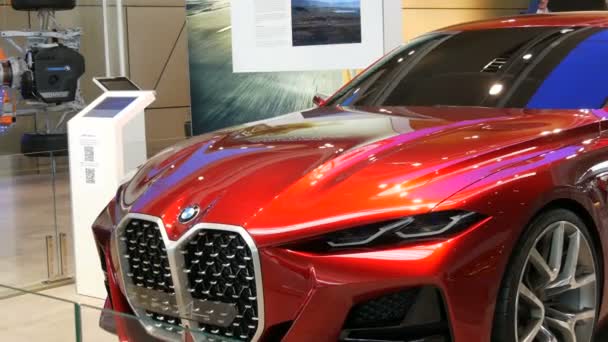 Munich, Germany - October 25, 2019: Beautiful bright red modern car on exhibition hall in the BMW complex. New advanced cars stand at exhibition. New modern cars from the BMW Welt concern. — Stock Video