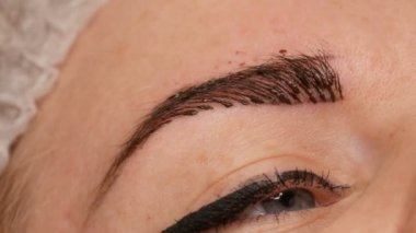Mikropatenli kaş dövmesi, kalıcı makyaj. Eldivenlerde uzman, özel bir iğne kullanarak, cilde pigmenti enjekte eder ve kaş boyalarını saç tekniği ile lekeler, onları doğal, yakın çekim görüntü yapar.