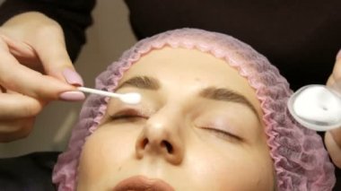 Kaplama ve botoks için profesyonel bir prosedür güzellik salonunda modern şifa kirpiklerini kirletir. Bir kozmetikçi tarafından kirpiklerin yüzeyine özel bir temizleme ve dezenfekte köpüğü uygulanır.