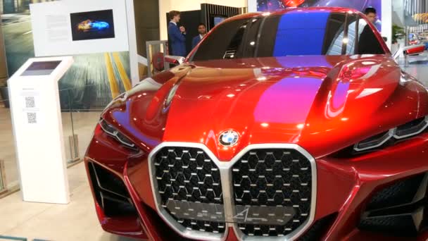 Munich, Germany - October 25, 2019: Beautiful bright red modern car on exhibition hall in the BMW complex. New advanced cars stand at exhibition. New modern cars from the BMW Welt concern. — Stock Video