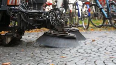 Temizlik makinesi fırçası sonbahar sokağından düşen sarı yaprakları temizliyor. Sonbaharda yaprakları temizliyorum. Almanya 'da asfalt makinesi temizliği, Münih