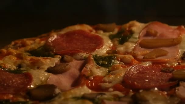 Lahodná pizza s houbami, salámem, slaninou, bylinkami a sýrem se vaří v troubě — Stock video