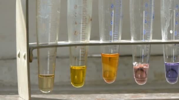 实验室里的医用试管，装有彩色液态水，实验室里有试剂，窗上有大理石窗台. — 图库视频影像
