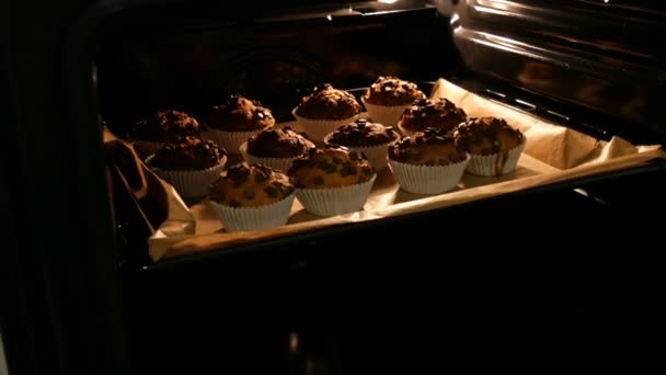A finom muffinokat a papírformákban sütőben sütik. — Stock videók