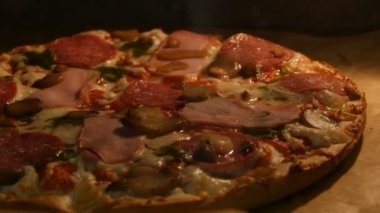 Fırında pişmiş güzel, lezzetli pizzanın yakın görüntüsü. Evde domuz pastırmalı, salamlı, otlu ve peynirli İtalyan pizzası pişirilir..