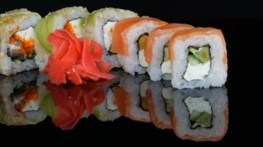 Renkli suşi çeşitli siyah bir arka plan ayna yüzeyinde setleri ve zencefil alır. Studio Japon mutfağı