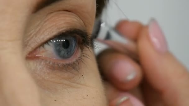 Make up artist gör ögonmakeup till medelålders kvinna med blå ögon. Åldersmink. Närbild porträtt. Applicera puder med borste — Stockvideo