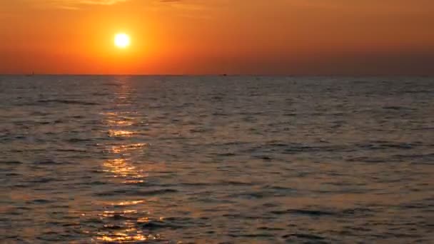 Picturesque huge round red sunset or dawn at sea sun over water surface. Reflected in sea sun ray and sunrise over the calm sea — Stock Video