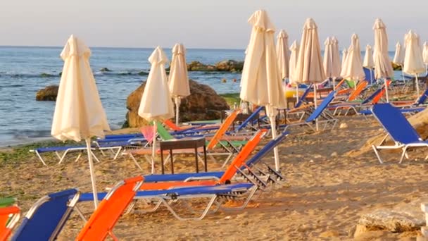 Vacaciones de lujo en el Mar Negro, Bulgaria. Tumbonas vacías multicolores o tumbonas y sombrillas plegadas en la playa del resort — Vídeos de Stock