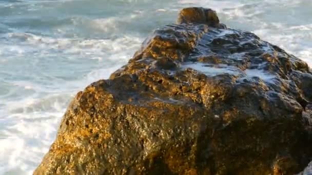 De grosses vagues puissantes s'écrasent dans les énormes rochers. Tempête en mer. De grosses vagues se brisent sur le rivage rocheux, de la mousse blanche sur l'eau vue de près. Mer Noire, Bulgarie — Video