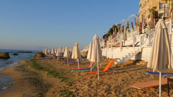 Vacaciones de lujo en el Mar Negro, Bulgaria. Tumbonas vacías multicolores o tumbonas y sombrillas plegadas en la playa del resort — Vídeo de stock