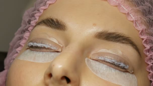 Amélioration professionnelle des cils dans un salon de beauté. Agent spécial est appliqué sur les cils — Video