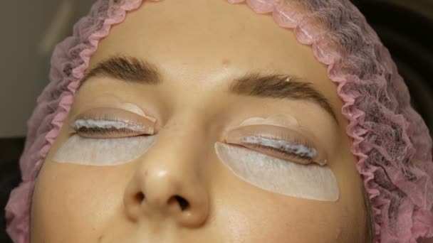 Amélioration professionnelle des cils dans un salon de beauté. Agent spécial est appliqué sur les cils — Video