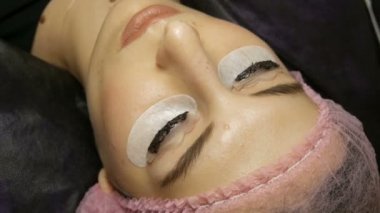 Genç bayan kirpikleri özel siyah boyayla boyama prosedürü hakkında yalan söylüyor.