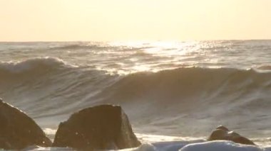 Büyük güçlü dalgalar büyük kayalara çarpar. Denizde fırtına. Büyük dalgalar kayalık sahilde, beyaz köpükler suda kırılır. Karadeniz, Bulgaristan