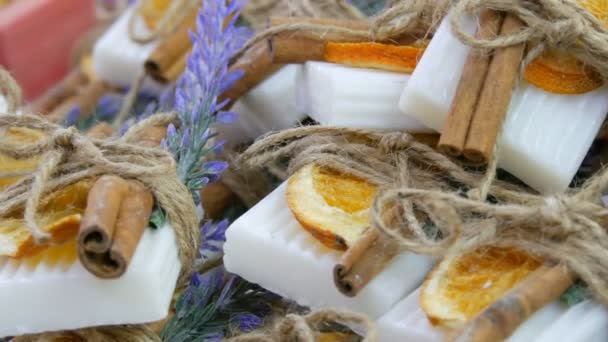 Sapone bianco fatto a mano splendidamente decorato con fette di arancia secca, bastoncini di cannella e rametti di lavanda sul bancone del negozio . — Video Stock