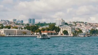 İstanbul, Türkiye - 12 Haziran 2019: Yeşilliklerle çevrili deniz kıyısındaki yeşil tepelerdeki konut binalarının zengin lüks çeyreği. Yoldan geçen bir tekneden görüntü