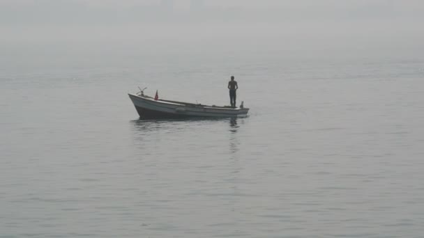 Silhuett av fiskare som fiskar i havet med båt — Stockvideo