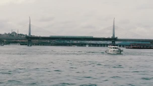 Istanbul, Türkei - 11. Juni 2019: 11. Juni 2019: Touristenschiff, das unter einer Brücke im Marmarameer fährt. Blick vom Pier eminenu — Stockvideo