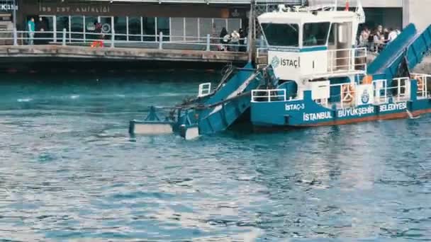 Istanbul, Türkei - 11. Juni 2019: Ein Wasseraufbereitungsschiff reinigt das Wasser und den Müll aus dem Marmarameer in der Nähe der Seebrücke. Seeschiff entfernt Müll aus dem Wassergebiet von Istanbul — Stockvideo