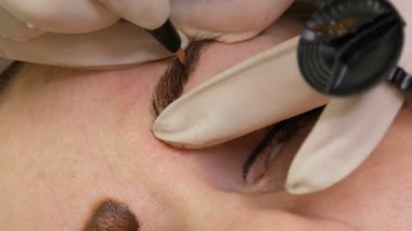 Mikropatenli kaş dövmesi, kalıcı makyaj. Eldivenlerde uzman, özel bir iğne kullanarak, cilde pigmenti enjekte eder ve kaş boyalarını saç tekniği ile lekeler, onları doğal, yakın çekim görüntü yapar.