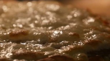 Peynir ile zengince serpilmiş lezzetli pizza fırında pişirilir. Pizzanın üzerindeki peynir fırının ısısından erir.