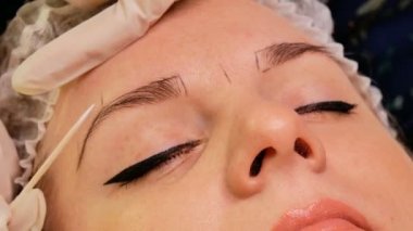 Güzellik uzmanı hastasına kaş düzeltmesi yapıyor. Kaşların dış hatlarını özel bir kalemle işaretliyorum.