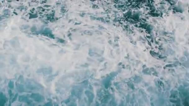 Piękna turkusowa woda morska z falami i białą pianką z bliska widok z góry. Statek unosi się na morzu i tnie fale. — Wideo stockowe