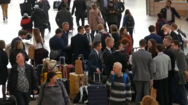 Münih, Almanya - 25 Ekim 2019: Merkezi tren istasyonu. Takım elbiseli ve bavullu bir grup insan birbirini selamlıyor.