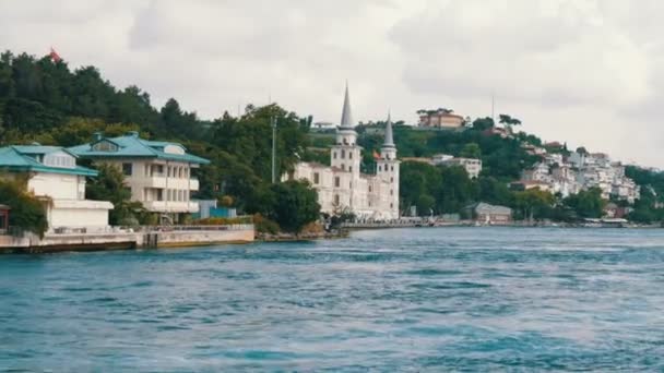 Богатый роскошный квартал жилых зданий на зеленых холмах на берегу моря, которые окружены зеленью. Вид с проходящей лодки, Стамбул, Турция — стоковое видео