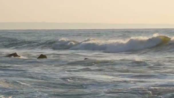 Stora kraftiga vågor kraschar in i de stora klipporna. Stormen till havs. Stora vågor bryter på den steniga stranden, vitt skum på vattnet. Svarta havet, Bulgarien — Stockvideo