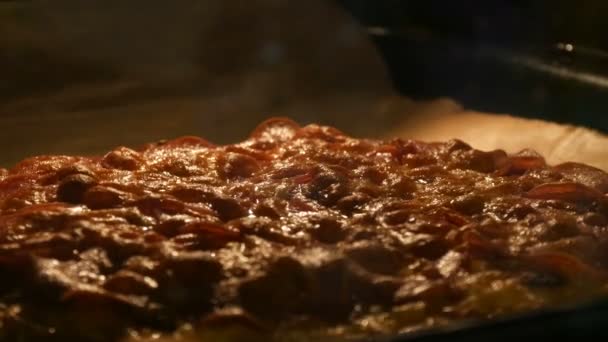 Ost på pizza smälter av ugnsvärme. Smaklig italiensk pizza salami och ost rostad i ugn närbild — Stockvideo