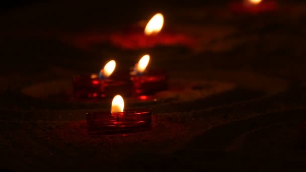 Velas funerarias rojas y redondas sobre arena en un templo católico. Luz de las velas en la oscuridad — Vídeos de Stock