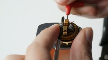 Bir adam kahverengi elektronik sigaraya yeni bir demir bobini yerleştiriyor.