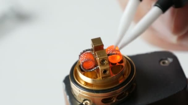 A man inserts new iron coil into a brown electronic cigarette — 비디오