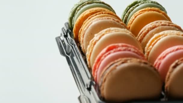 Macaron de biscoitos franceses multicoloridos em uma caixa preta especial em uma mesa branca. Macaroon bolo colorido em uma caixa de presente — Vídeo de Stock