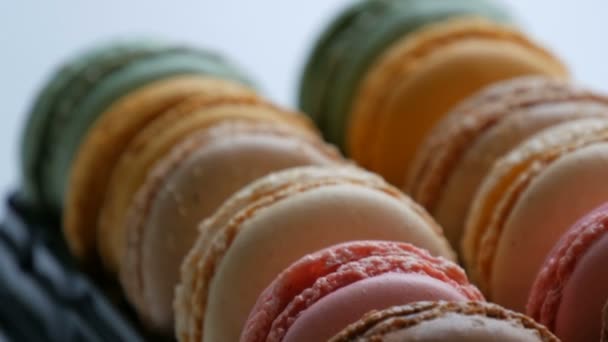 Coloridos macarrones franceses en caja de regalo sobre un fondo blanco — Vídeos de Stock