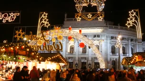 Wien, Österrike - 21 december 2019: Julmarknad framför stadshuset. Festligt inredda torget med kransar nära vilka turister och lokalbefolkningen gå. Stall med olika mat och saker — Stockvideo