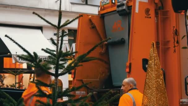 Βιέννη, Αυστρία - 21 Δεκεμβρίου 2019: Σκουπιδιάρικο που σηκώνει πλαστικά σκουπίδια και πετάει σκουπίδια μέσα στο μηχάνημα. Καθαρισμός δρόμων, άντρες που φορτώνουν απόβλητα από κάδους. — Αρχείο Βίντεο