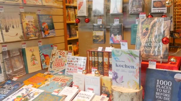 Viena, Austria - 19 de diciembre de 2019: Una variedad de libros en alemán en la ventana de la vieja librería en invierno — Vídeo de stock