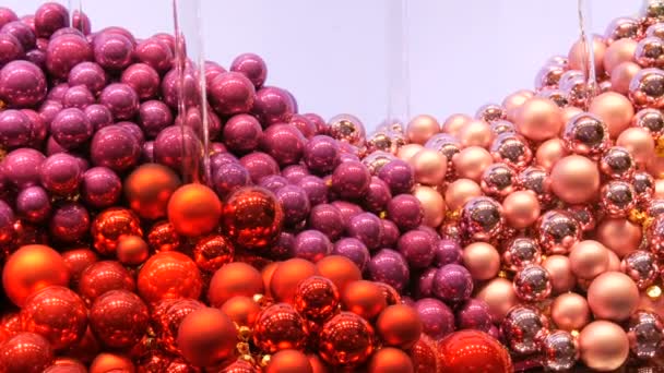 Nagyszámú szilveszteri és karácsonyfa labdák rózsaszín, piros, lila a bolt ablakában. Karácsonyi dekoráció — Stock videók