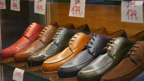 Полки в витрине обувного магазина с различной классической кожаной мужской обувью различных цветов с ценниками со скидками — стоковое видео