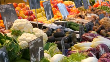Büyük şehirde sebze pazarı. Çok çeşitli sebze ve meyve çeşitleri var. Tezgahta sağlıklı taze organik vegan yiyecekler var. Fiyat etiketleri Almanca