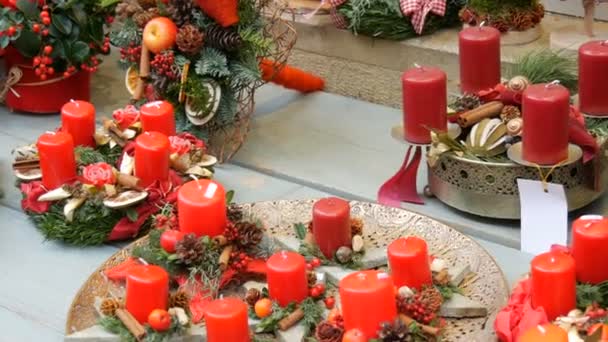 Όμορφα διακοσμημένες χριστουγεννιάτικες συνθέσεις διακόσμησης κόκκινων κεριών και στεφάνων στη βιτρίνα του καταστήματος — Αρχείο Βίντεο
